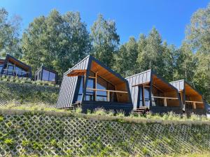 a group of modular homes on a hill with trees at Krusta Panoramic Resort in Râșca