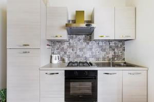 a kitchen with white cabinets and a stove top oven at Agritur Michelotti Giancarlo in Arco +93 photos