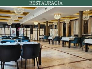 ein Restaurant mit weißen Tischen und Stühlen und Kronleuchtern in der Unterkunft Hotel RED in Ostrowiec Świętokrzyski