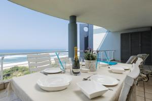 a table with white plates and a bottle of wine at Indigo Bay 33 in Margate
