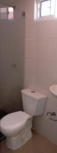 une salle de bain blanche avec toilettes et lavabo dans l'établissement Hostal altos de riomar Barranquilla inn, à Ciudad Jardín