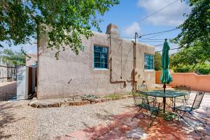 a table with a green umbrella in front of a building at Casa Mirador in Santa Fe