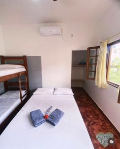 a bedroom with a bed with a pair of shoes on it at Doce Lar Hospedaria in Lençóis