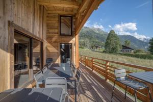 una terrazza con tavolo e sedie su una casa di Magnifique chalet mitoyen - Jacuzzi - Cousinade II a Les Contamines-Montjoie