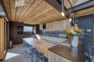 una grande cucina con tavolo e sedie lunghi di Magnifique chalet mitoyen - Jacuzzi - Cousinade II a Les Contamines-Montjoie Altre 43 foto