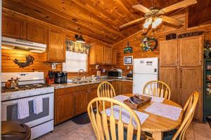 a kitchen with a table and a stove and refrigerator at Blue Mist Mountain Retreat in Whittier