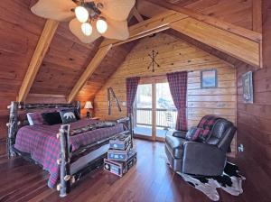 a bedroom with a bed and a chair in a cabin at High Haven in Bryson City