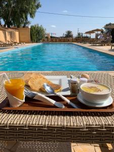 a breakfast tray with toast and coffee and a bowl of orange juice at Al Kasbah Resort in El Jadida +20 photos