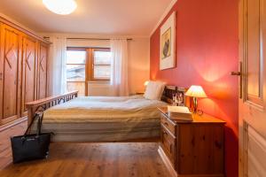 a bedroom with a bed and a desk and a window at Landhaus Resinger in Bad Hofgastein