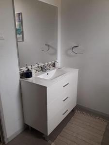 ein weißes Badezimmer mit Waschbecken und Spiegel in der Unterkunft jolie maison de ville in Limoux