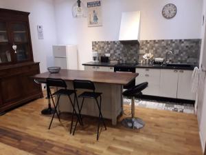 eine Küche mit einem Holztisch und vier Hockern in der Unterkunft jolie maison de ville in Limoux