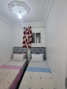 ein Zimmer mit zwei Betten und einem Fenster in der Unterkunft Marrakech in Marrakesch