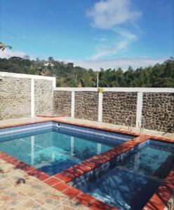 a swimming pool in front of a stone wall at alquilo en el queremal valle del cauca colombia in Papagalleros