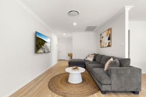 a living room with a couch and a table at Pipis Huskisson by Experience Jervis Bay in Huskisson