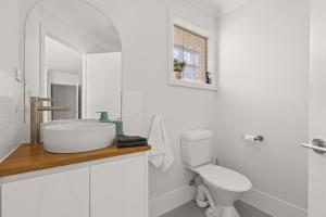 a white bathroom with a sink and a toilet at Pipis Huskisson by Experience Jervis Bay in Huskisson +16 photos