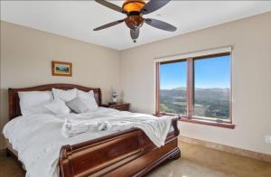 Un dormitorio con una cama y un ventilador de techo. en Breathtaking Retreat, en Escondido