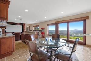 Una cocina y un comedor con una mesa de cristal y sillas. en Breathtaking Retreat, en Escondido