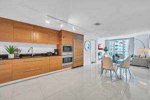 迈阿密Unique 1BR Icon Brickell WaterViews-Freespa的厨房配有木制橱柜和桌椅