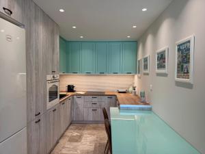 a kitchen with green cabinets and a counter top at Modern, chic, near a Blue Flag beach, 100 sq m in Korinthos