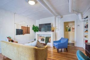 ein Wohnzimmer mit einem Sofa und einem blauen Stuhl in der Unterkunft Historic 1Bdrm - Parking - Walk to Restaurants & Westport! in Kansas City