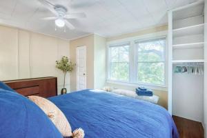 Schlafzimmer mit einem blauen Bett und einem Deckenventilator in der Unterkunft Historic 1Bdrm - Parking - Walk to Restaurants & Westport! in Kansas City
