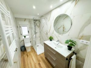 un bagno con lavandino e specchio di El Mastin del Pirineo Turistea a Huesca Altre 30 foto