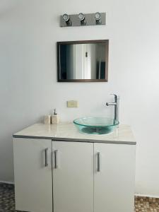 a bathroom with a sink and a mirror on the wall at Departamento en zona dorada de Tijuana in Tijuana
