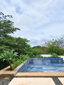 a swimming pool in the middle of a garden at Villa Gaspar Terrazas in Playa hermosa