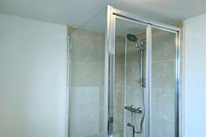 una ducha con puerta de cristal en un baño en Stylish City Centre Apartment with Parking, en Preston