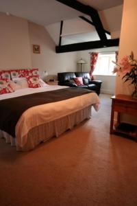 a bedroom with a large bed and a couch at Reddivallen Farmhouse in Boscastle