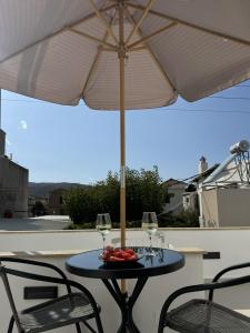 a table with an umbrella and two glasses of wine at Kasteli loft apartment in Kissamos