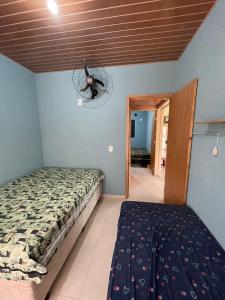 a bedroom with a bed and a fan on the wall at Casa com Piscina na Represa de Carlópolis in Carlópolis