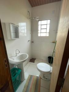a white bathroom with a sink and a toilet at Casa com Piscina na Represa de Carlópolis in Carlópolis +27 photos
