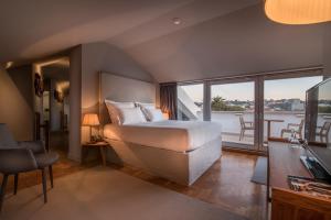 a bedroom with a large bed and a balcony at Villa Cascais Boutique Hotel in Cascais