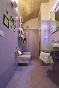 ein lila Badezimmer mit Toilette und Waschbecken in der Unterkunft Residenza Adriana in Rom + 22 Fotos