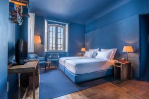 a blue bedroom with a bed and a television at Villa Cascais Boutique Hotel in Cascais