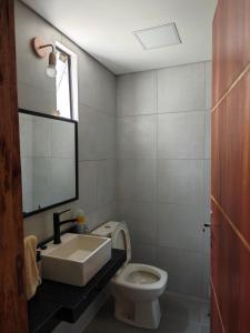 a bathroom with a sink and a toilet and a mirror at Casa Con Vista al Lago Ypacaraí in San Bernardino