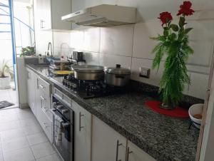 cocina con fogones y algunas ollas y sartenes en Habitación con vista al mar, en Lima 3 fotos más