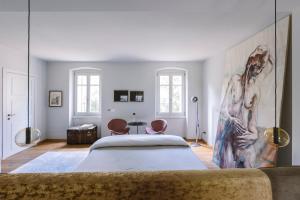 a room with a bed and a painting on the wall at Corte Lanfranconi Private Villa Retreat & Biolake in Pescantina