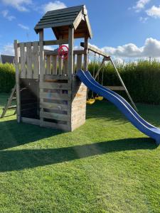 a wooden playset with a slide and a slideintend at Ker-Lina sea view, calm guaranteed in Plounévez-Lochrist
