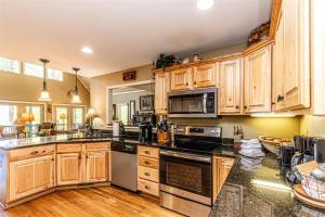 Una cocina con gabinetes de madera y electrodomésticos de acero inoxidable. en Bruins Den, en Bryson City