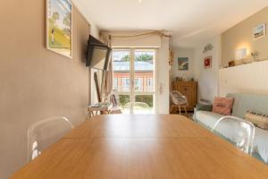 ein Esszimmer mit einem Holztisch und Stühlen in der Unterkunft Appartement pour 4 pers avec piscine tennis et parking 56 in Le Touquet-Paris-Plage