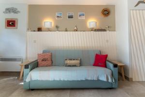 eine blaue Couch mit zwei Kissen darauf in einem Zimmer in der Unterkunft Appartement pour 4 pers avec piscine tennis et parking 56 in Le Touquet-Paris-Plage