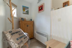 ein Wohnzimmer mit einem Stuhl und einem Kissen in der Unterkunft Appartement pour 4 pers avec piscine tennis et parking 56 in Le Touquet-Paris-Plage + 10 Fotos