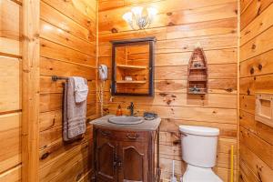 a wooden bathroom with a toilet and a sink at Edge View Chalet in Bryson City +33 photos