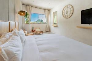 1 dormitorio con 1 cama blanca grande y reloj en la pared en Blanko Mar Ocean view, en Santa Teresa Beach