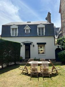 a table and chairs in front of a house at Villa Victor Hugo in Deauville