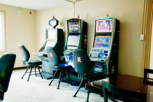 two video game machines in a room with chairs at Country Garden & Suites in Benton