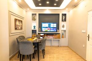 a dining room with a table and chairs and a tv at Alpacino Apart Hotel in Istanbul
