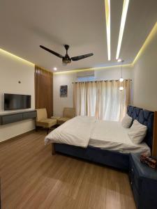 a bedroom with a bed and a couch and a television at Fellows BnB in Dhok Sandemār